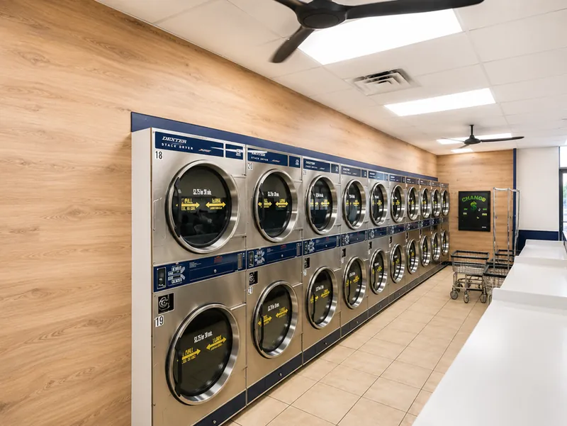Rows of stacked Dexter dryers along a warm wood-panelled wall, with laundry carts alongside